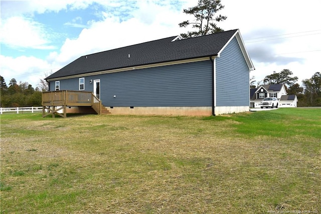 rear view of property featuring a yard and a deck