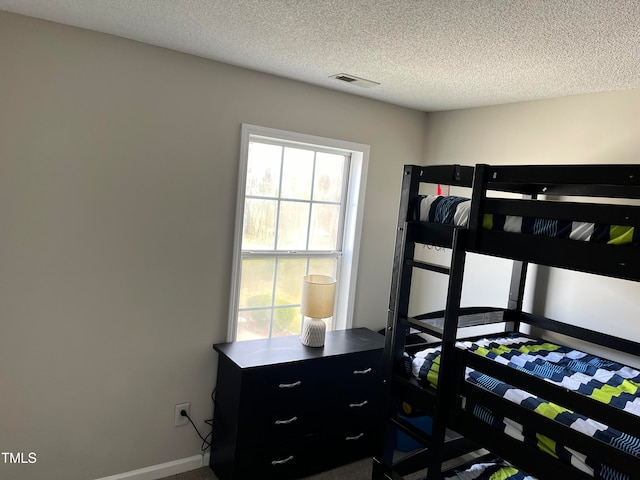 bedroom with multiple windows and a textured ceiling