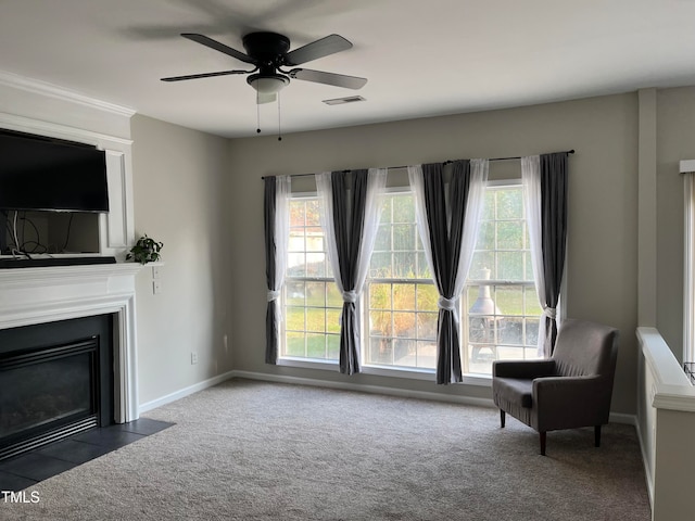 sitting room featuring ceiling fan and dark colored carpet