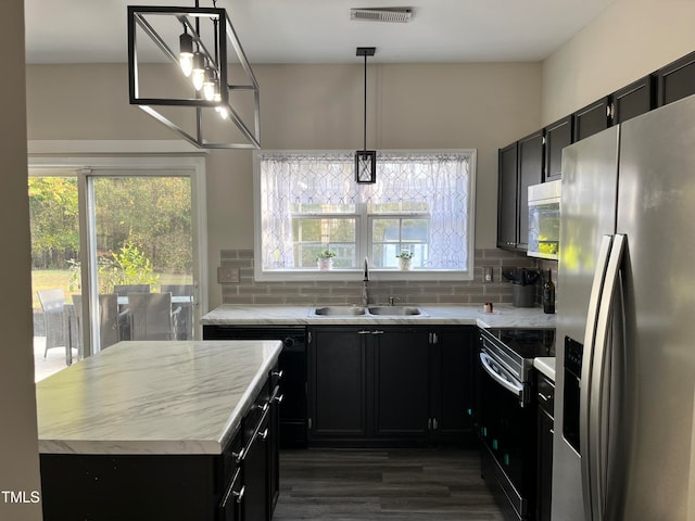 kitchen featuring sink, appliances with stainless steel finishes, backsplash, hanging light fixtures, and dark hardwood / wood-style flooring