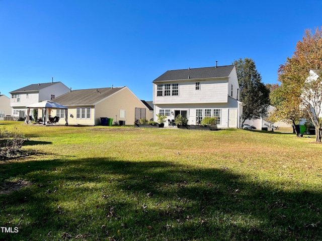 rear view of house with a yard and a gazebo