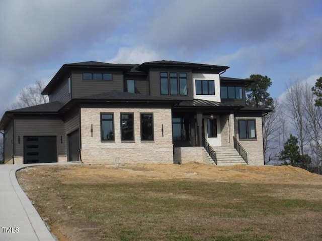 prairie-style house featuring a front lawn, a porch, and a garage