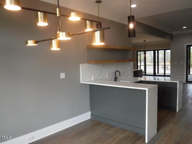 kitchen featuring pendant lighting, dark hardwood / wood-style floors, and kitchen peninsula