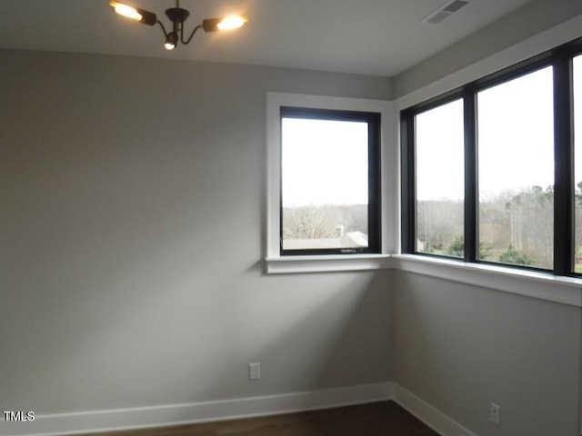 unfurnished room with a healthy amount of sunlight and dark hardwood / wood-style floors