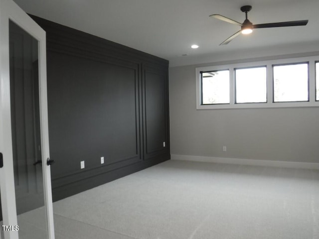 unfurnished room featuring ceiling fan and light carpet