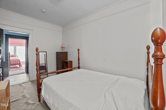 bedroom with ornamental molding and carpet