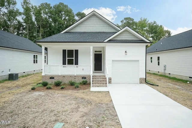 view of front of house featuring covered porch, a garage, and central AC unit