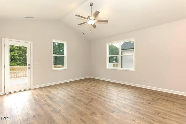 unfurnished room featuring lofted ceiling, a healthy amount of sunlight, light wood-type flooring, and ceiling fan