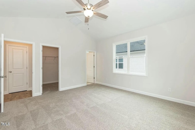 unfurnished bedroom featuring a spacious closet, ceiling fan, high vaulted ceiling, light carpet, and a closet