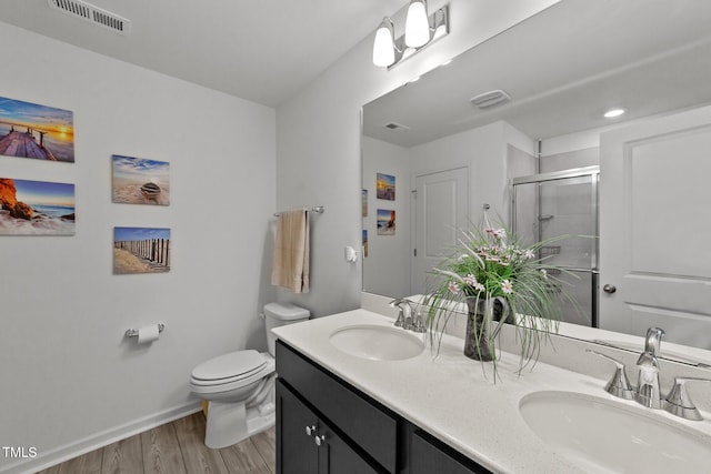 bathroom with vanity, hardwood / wood-style flooring, toilet, and walk in shower