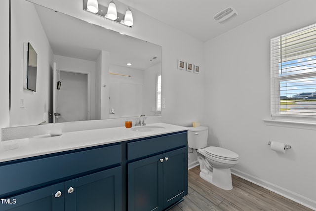 bathroom featuring vanity, hardwood / wood-style flooring, and toilet