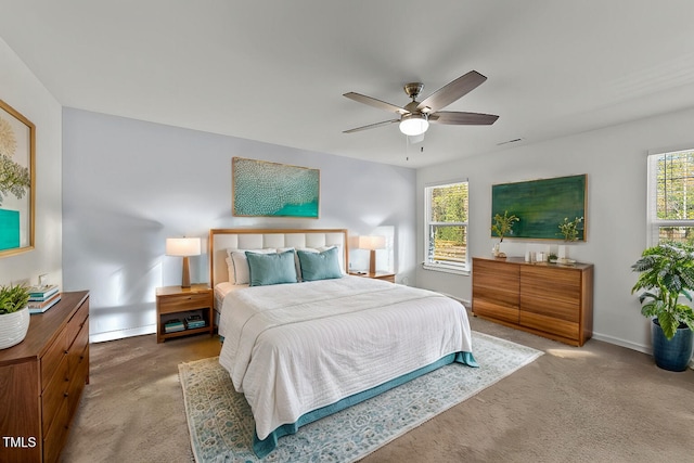 carpeted bedroom with multiple windows and ceiling fan