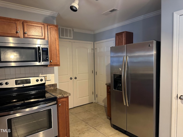 kitchen featuring appliances with stainless steel finishes, ornamental molding, dark stone counters, light tile patterned floors, and decorative backsplash