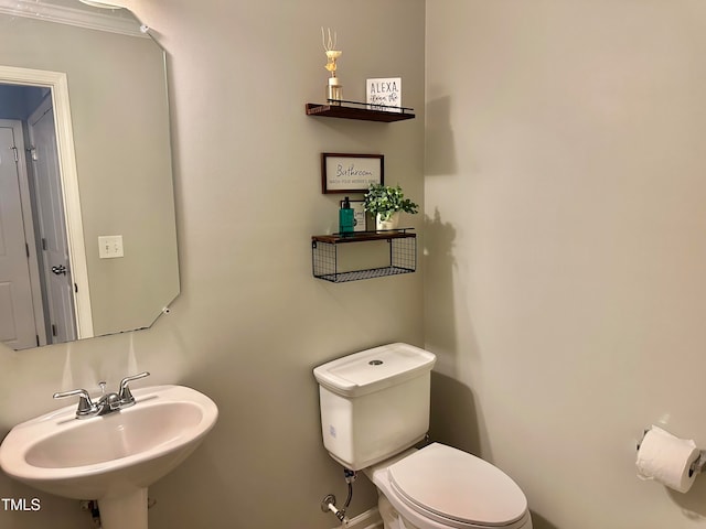 bathroom with crown molding, sink, and toilet