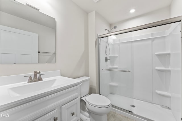 bathroom with toilet, vanity, hardwood / wood-style floors, and a shower with door