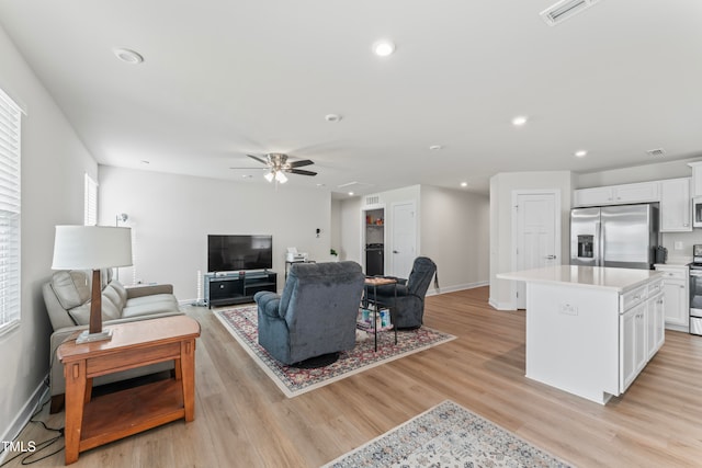 living room with ceiling fan and light hardwood / wood-style floors