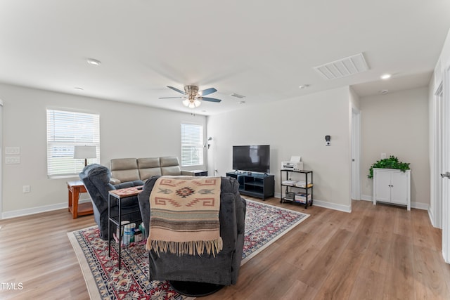 living room featuring light wood-type flooring and ceiling fan