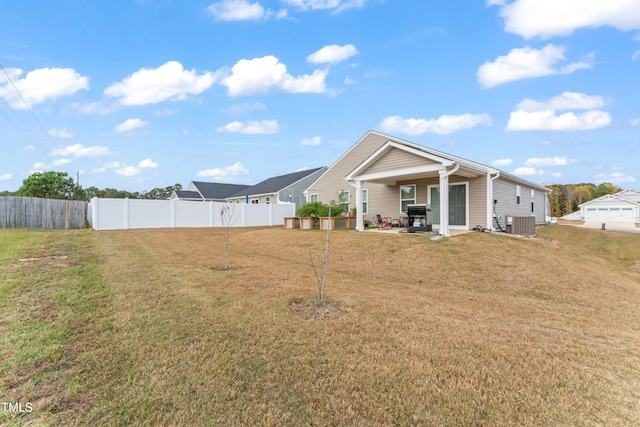 back of property featuring central air condition unit and a yard