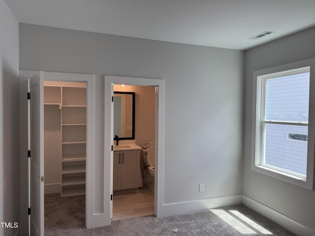 122 Sanderway Dr, Chapel Hill, NC 27516 - unfurnished bedroom with a walk in closet, light colored carpet, multiple windows, and a closet