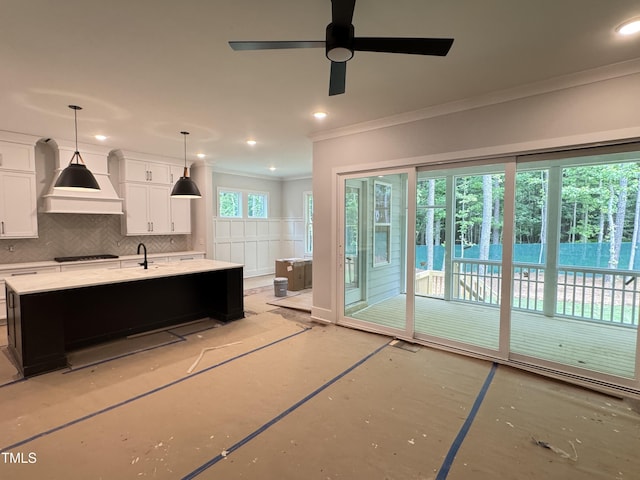 122 Sanderway Dr, Chapel Hill, NC 27516 - kitchen with ornamental molding, premium range hood, white cabinets, backsplash, and an island with sink