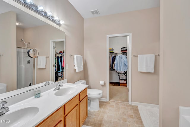 bathroom with a shower with shower door, vanity, and toilet