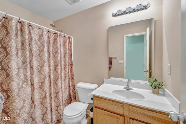 bathroom featuring toilet, vanity, and a shower with shower curtain