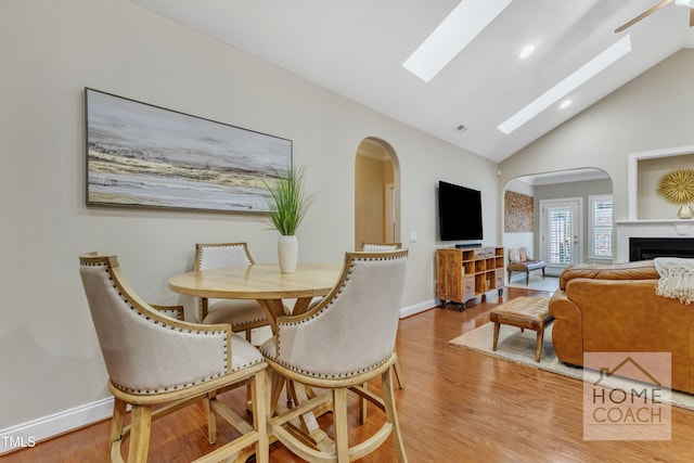 dining room featuring light wood-type flooring and high vaulted ceiling