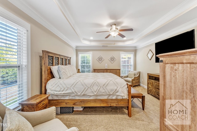 bedroom featuring ceiling fan, light carpet, crown molding, and a tray ceiling