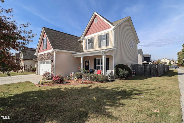 view of front of property with a garage, covered porch, and a front lawn