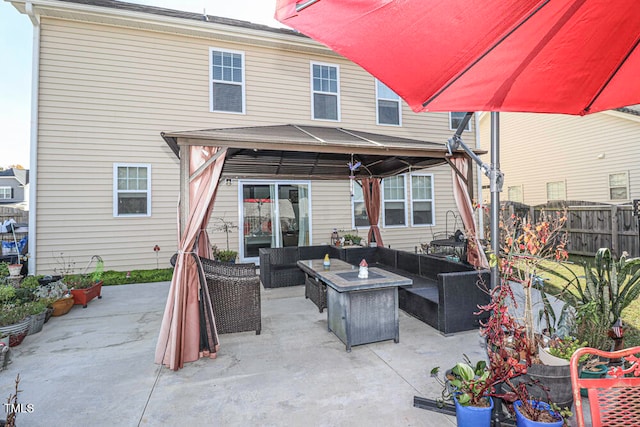 rear view of house with a patio, a gazebo, and an outdoor living space with a fire pit