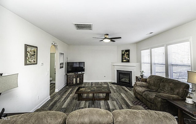 living room featuring ceiling fan and dark wood-type flooring