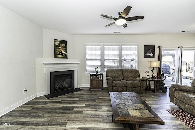 living room featuring ceiling fan and dark hardwood / wood-style flooring