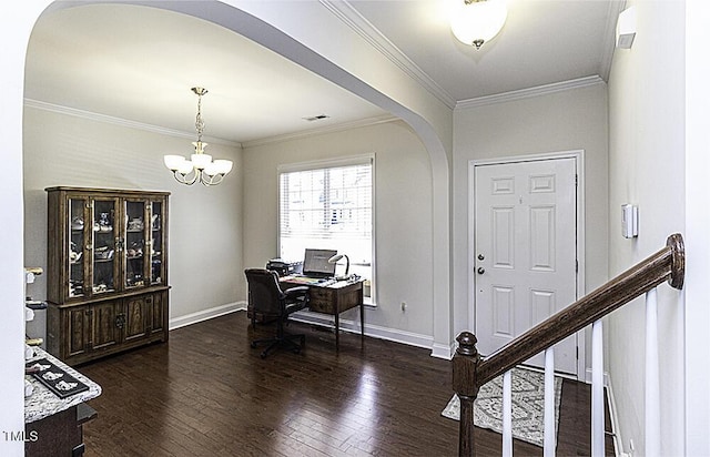 foyer entrance featuring dark hardwood / wood-style floors, ornamental molding, and an inviting chandelier