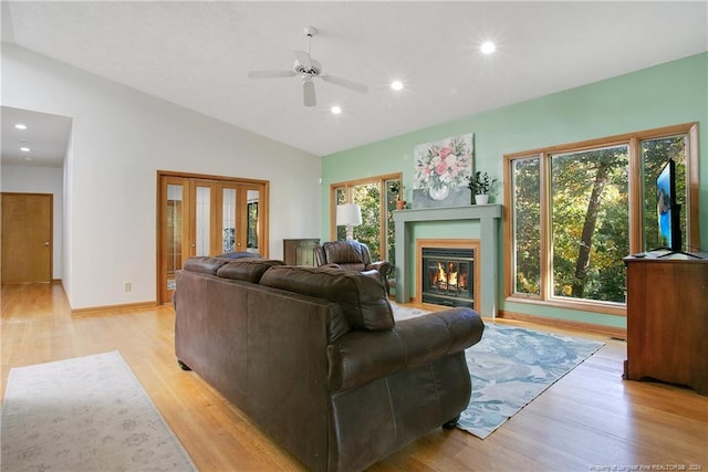 living room featuring lofted ceiling, ceiling fan, and light hardwood / wood-style flooring