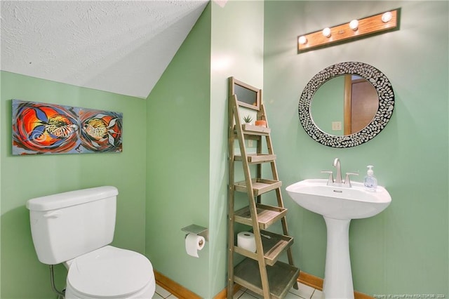 bathroom with tile patterned flooring, lofted ceiling, a textured ceiling, and toilet