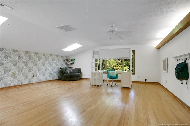 additional living space with ceiling fan, a textured ceiling, light hardwood / wood-style flooring, and vaulted ceiling