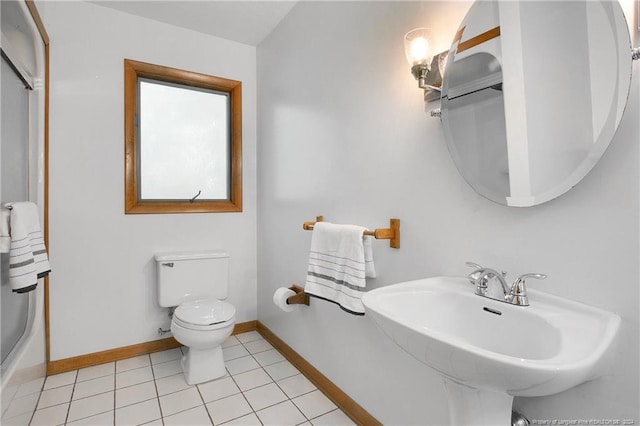 bathroom featuring toilet, sink, and tile patterned flooring