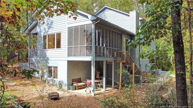 rear view of property featuring a patio and a sunroom