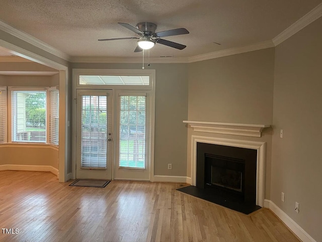 entryway with a textured ceiling, light wood-type flooring, ceiling fan, and crown molding