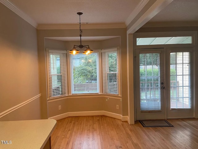 doorway to outside with a wealth of natural light, ornamental molding, french doors, and hardwood / wood-style flooring