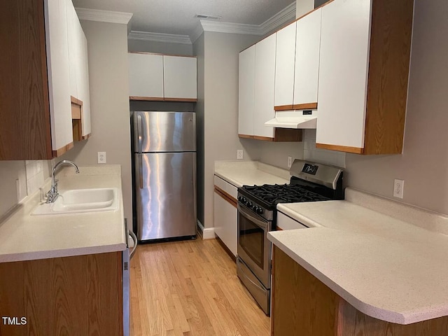 kitchen featuring stainless steel appliances, white cabinetry, sink, ornamental molding, and light hardwood / wood-style flooring