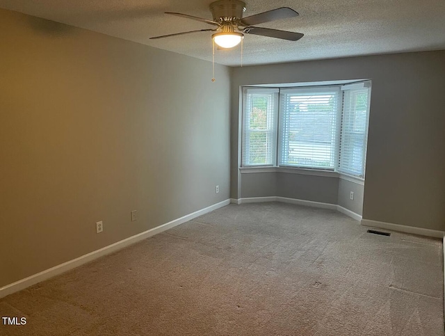 carpeted empty room with a textured ceiling and ceiling fan