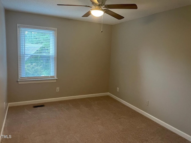 unfurnished room with ceiling fan and carpet