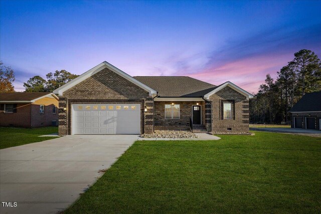 view of front of house with a garage and a yard