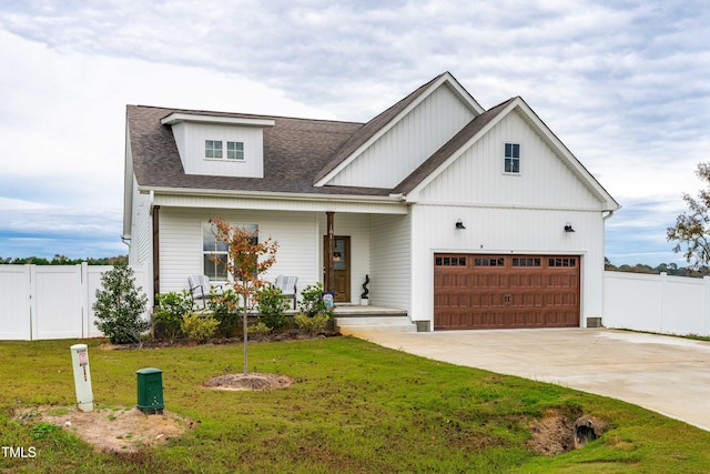 modern inspired farmhouse with covered porch, a garage, and a front lawn