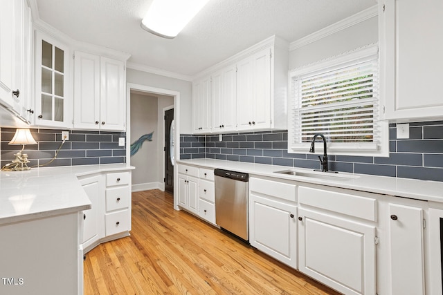 kitchen featuring white cabinetry, dishwasher, sink, light hardwood / wood-style floors, and ornamental molding