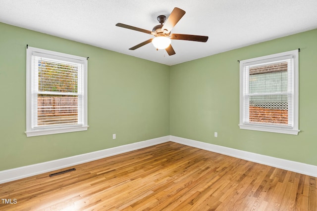 unfurnished room featuring ceiling fan, a textured ceiling, and light wood-type flooring