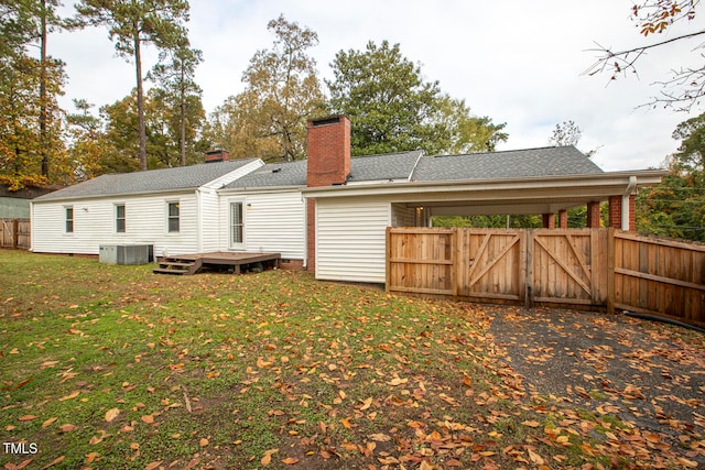 back of property featuring a yard, a wooden deck, and central AC