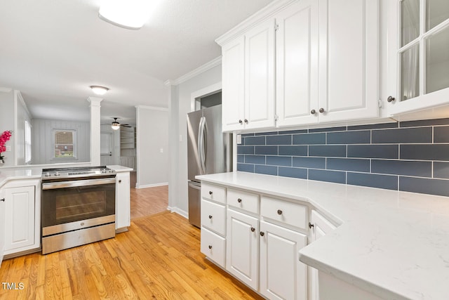 kitchen with white cabinets, light wood-type flooring, backsplash, and appliances with stainless steel finishes