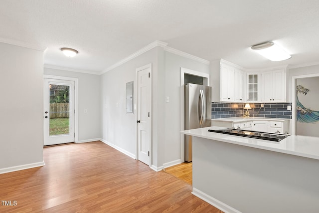 kitchen with white cabinets, stainless steel fridge, light hardwood / wood-style flooring, and ornamental molding